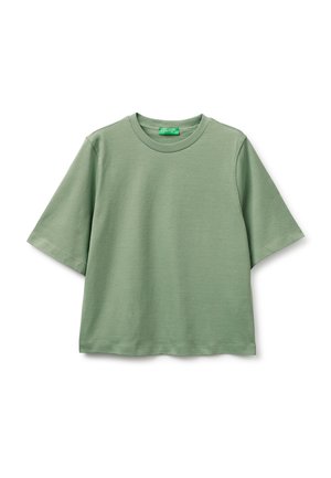 Jasnozielona koszulka z krótkim rękawem, okrągłym dekoltem, o lekko luźnym kroju i prążkowanym kołnierzu, prezentowana na białym tle.