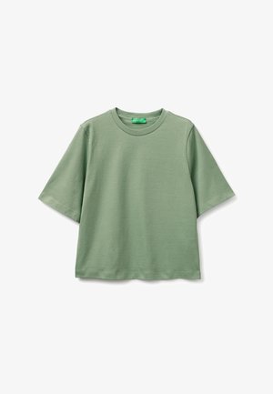 Jasnozielona koszulka z krótkim rękawem, okrągłym dekoltem, o lekko luźnym kroju i prążkowanym kołnierzu, prezentowana na białym tle.