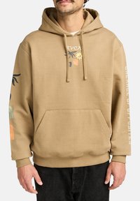 Tan hooded sweatshirt made of cotton, featuring a front pocket, and colorful graphic designs on the chest and sleeve.