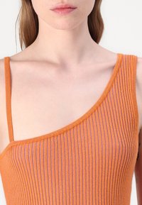 Geribbelde gebreide top in oranje en paars, met een one-shoulder ontwerp, dunne bandjes en een gestructureerd oppervlak.