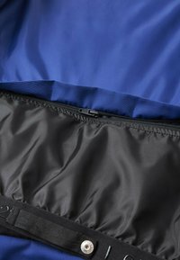 Marineblaues Stoffinterieur mit einer glatten Textur, das einen schwarzen Reißverschlussbereich und ein elastisches Banddetail entlang der unteren Kante aufweist.