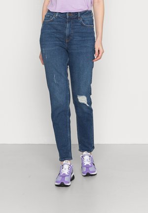 Jeans azuis de cintura alta com um corte ligeiramente ajustado, apresentando detalhes desgastados e um design clássico de cinco bolsos, combinados com ténis roxos.