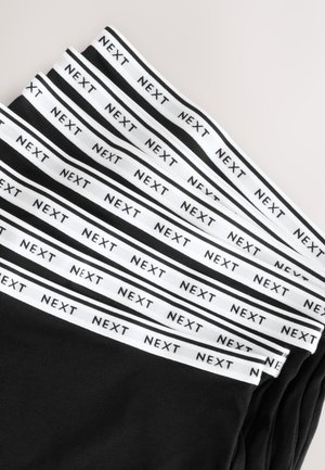 Boxers noirs pour hommes avec des tailles élastiques blanches. Les tailles présentent le logo "NEXT" répété et sont soigneusement disposées en couches.