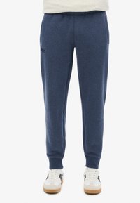 Mørkeblå sweatpants lavet af blød stof, med elastisk talje, sidelommer og ribbede manchetter. Diskret logodetalje på benet.