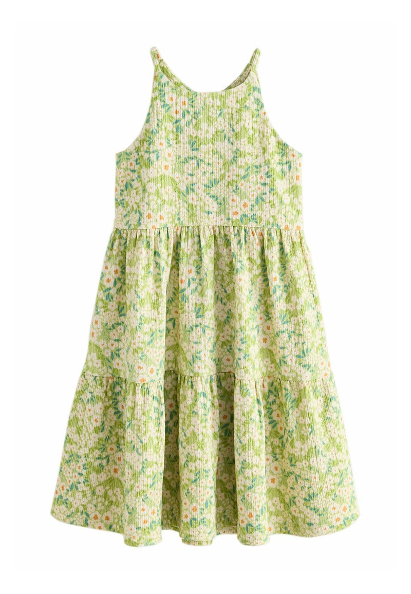 Vihreä kukallinen mekko, jossa on tiukka yläosa ja kerroksellinen röyhelöhame. Sisältää säädettävät olkaimet ja teksturoidun, kudotun kankaan.