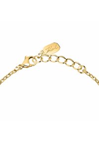 Bracelet chaîne en or avec un fermoir mousqueton, présentant des maillons imbriqués et une plaque gravée du nom "Karl". Texture lisse, finition brillante.