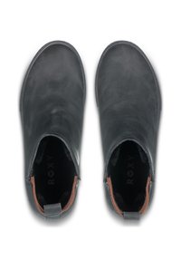 Botas de tobillo de cuero negro con un acabado suave y un acento marrón claro cerca de la cremallera. Presentan un tirador en la parte posterior y un suave forro interior.
