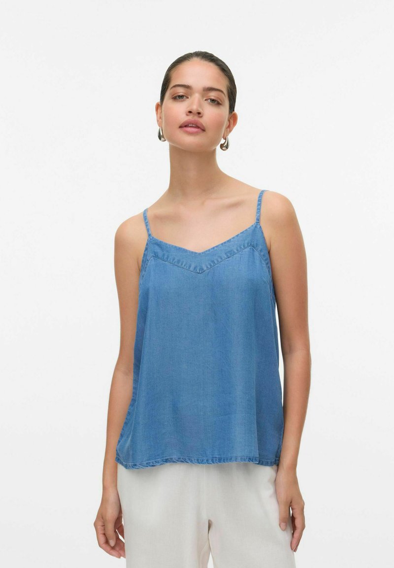 Canotta in denim azzurro chiaro con spalline regolabili, scollatura a V e vestibilità morbida. Presenta un orlo a onde e dettagli di cucitura minimal.