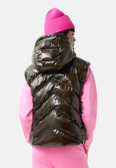 Brązowa, połyskująca kamizelka puchowa z kapturem i wzorem w jodełkę, noszona na różowej bluzie. Na plecach znajduje się naszywka z logo.
