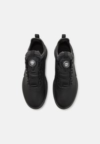 Black athletic shoes with a smooth upper, featuring a Boa lacing system, textured accents, and a rounded toe design.