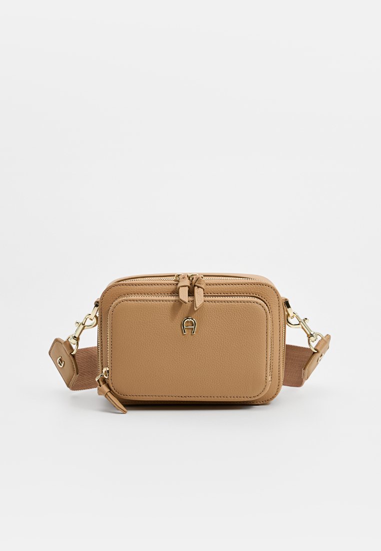 Tann korsryggsbag i strukturerad konstläder, med dragkedjestängning, detaljer i guld och justerbar rem.