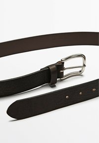 Ceinture en cuir marron avec une boucle en métal argenté, présentant une texture lisse et plusieurs trous régulièrement espacés pour les ajustements.