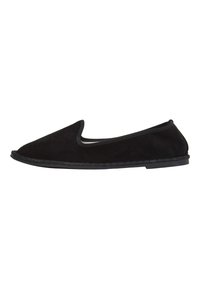 Scarpa slip-on in suede nero con punta arrotondata e bordo elastico. Presenta una suola piatta in gomma con cuciture dettagliate lungo il bordo.