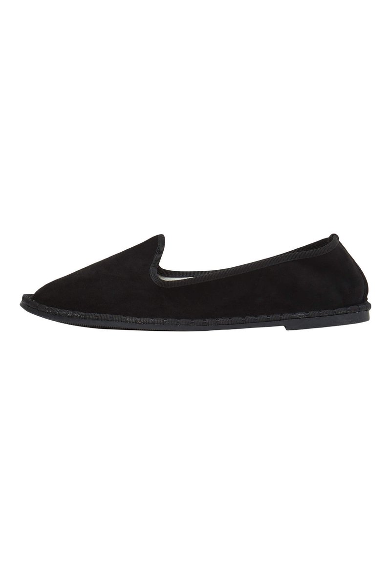 Scarpa slip-on in suede nero con punta arrotondata e bordo elastico. Presenta una suola piatta in gomma con cuciture dettagliate lungo il bordo.