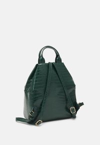 Zaino in ecopelle verde effetto coccodrillo con doppio manico superiore e spallacci regolabili. Texture liscia, forma strutturata e dettagli in metallo dorato.
