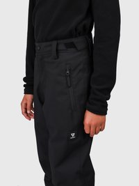 Person med svarte glidelåsbukser og en svart langermet topp, som viser en sidelomme med et merke-logo-patch.