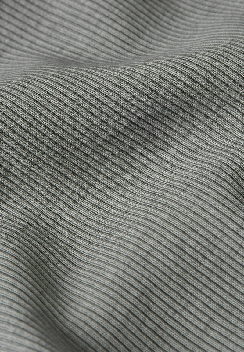 Tessuto grigio a coste, caratterizzato da una superficie texturizzata con sottili linee verticali. Materiale morbido con una leggera lucentezza e un drappeggio fluido.