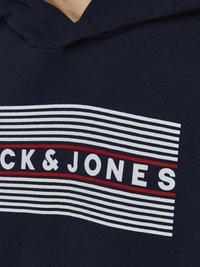 Marlena dukserica s kapuljačom u mornarskoj plavoj boji, s grafikom u bijeloj i crvenoj prugastoj šemi, s natpisom "CK&JONES" istaknutim na prednjem dijelu. Mekani pamučni materijal.