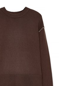 Brun stickad tröja med ribbad halsringning och ärmslut, med ett texturerat mönster och dekorativ sömnad på ärmarna.