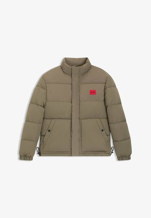 Kaki pufferjacka med hög krage, röd logotypapplikation, framfickor, elastiska muddar och dragsko i nederkant för justerbar passform.