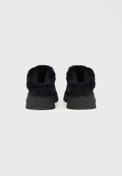 Czarne półbuty na wysokiej cholewce, z miękkim, puszystym wykończeniem, teksturowaną powierzchnią, grubą gumową podeszwą i zaokrąglonym kształtem, odpowiednie do codziennego użytku.