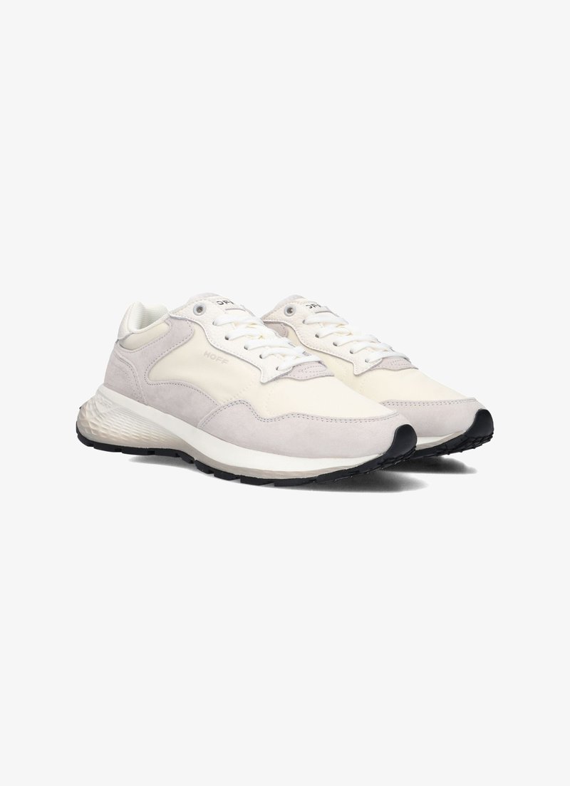 Sneaker gris clair et blanc présentant une combinaison de suède et de matériaux lisses, bout rond, design à lacets, et semelle en caoutchouc texturé.
