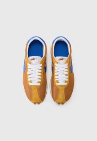 Ténis Nike em castanho e azul, com materiais em malha e camurça, atacadores brancos, palmilhas azuis acolchoadas e um distintivo logo swoosh.