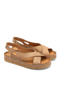 Beżowe skórzane sandały z krzyżującym się paskiem, otwartym piętą i wycięciami. Gruba gumowa podeszwa z detalami szycia.