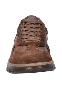 Bruine suède en leren casual schoen met dikke zool en veterluiting, getoond vanuit de teenhoek op een witte achtergrond.