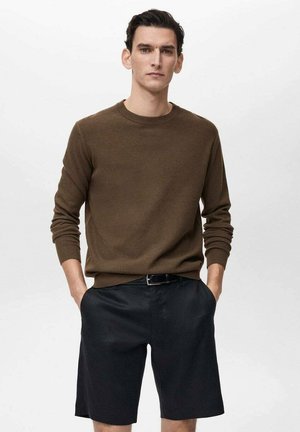 Brown knitted sweater with a round neckline paired with black tailored shorts, featuring a smooth texture and a relaxed fit.
