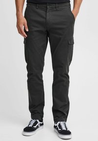 Dark grey cargo pants with side pockets, slim fit design, made from cotton blend fabric, paired with black and white sneakers.