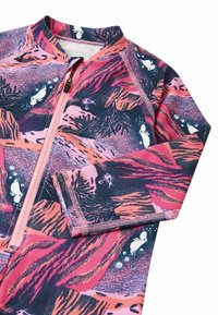 Różowy i granatowy rash guard z wzorami wodnymi, z suwakowym zamknięciem, długimi rękawami i kontrastowym przeszyciem. Teksturowany, rozciągliwy materiał.