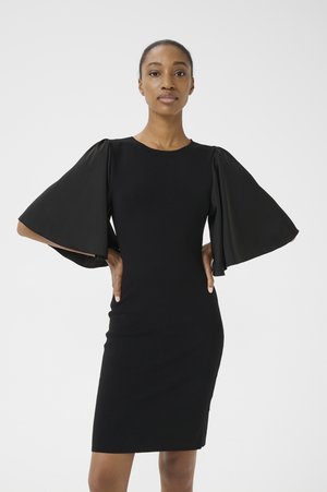 Black dress featuring textured fabric, fitted silhouette, and dramatic bell sleeves. Simple round neckline, knee-length design, and no additional accents.