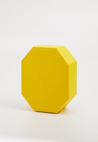 Boîte octogonale jaune avec une surface texturée et un logo en relief. Bords lisses et design solide et durable sans attaches visibles.