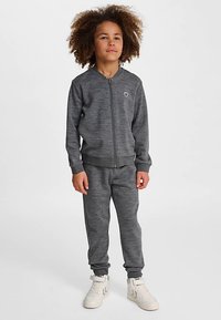 Graue Sportjacke mit Reißverschluss und passende Hose aus weichem Material. Mit gerippten Bündchen an Ärmeln und Bund sowie kleinem Logo auf der Brust.