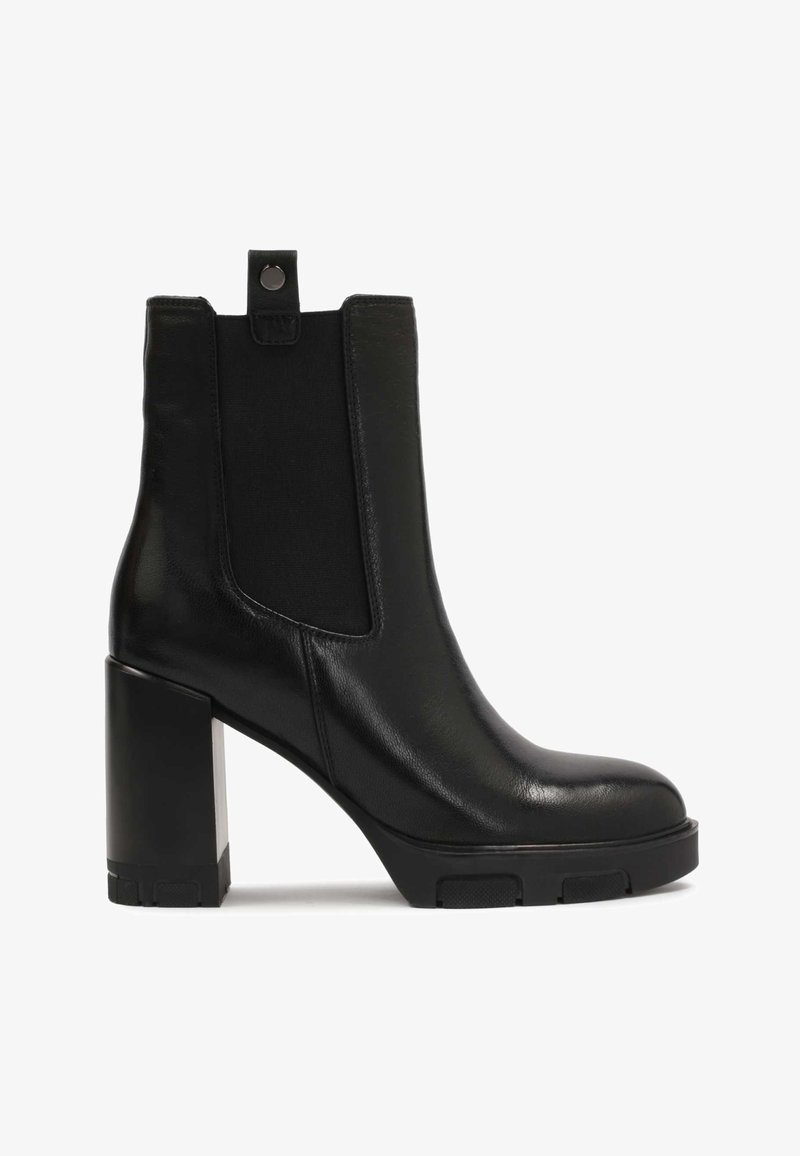 Stivale alla caviglia in pelle nera con tacco a blocco, pannelli laterali elasticizzati e linguetta di estrazione. Texture liscia con un design elegante e moderno.