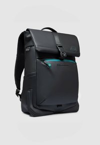 Zwarte rugzak met matte afwerking, voorzien van een overslagklep, verstelbare riemen, een aqua ritsaccent en een getextureerde bodem voor extra ondersteuning.