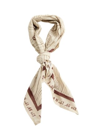 Écharpe beige clair avec des lignes topographiques brunes et des détails de coordonnées, nouée en un simple nœud sur fond blanc.