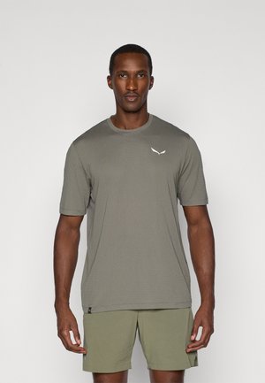 Viegls, īsām piedurknēm krekls olīvu zaļā krāsā ar ribotu tekstūru. Uz krūtīm ir smalka balta emblēma. Ideāls ikdienas valkāšanai.