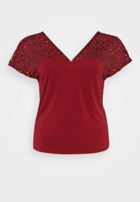 Top rojo con un diseño de cuello en V, mangas cortas con lentejuelas y un patrón floral, y tela suave en el cuerpo principal.