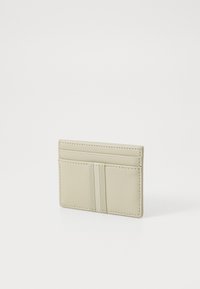 Portafoglio in pelle beige con quattro scomparti e due fasce elastiche nella parte anteriore, caratterizzato da una superficie liscia e un design rettangolare pulito.