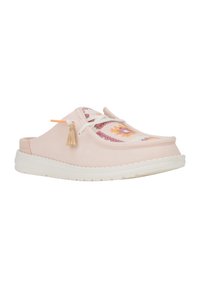 Zapato de tela rosa tipo slip-on con suela blanca, que presenta un diseño de ganchillo multicolor y detalle de borlas. Punta redondeada con cintas para ajuste.