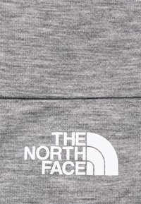 Šedý svetr z materiálu s texturovaným vzorem. Obsahuje bílé logo s nápisem "THE NORTH FACE" vedle zakřiveného grafického prvku.