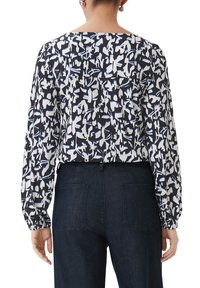 Langarmblouse met een zwart-wit abstract patroon en blauwe accenten, gemaakt van zachte stof, met een relaxte pasvorm en elastische mouwen.