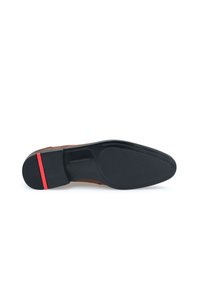 Semelle de chaussure en cuir marron avec une base en caoutchouc noir, agrémentée d'un accent rouge. Texture lisse et forme arrondie avec des détails d'adhérence.