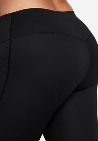 Svarte høytlivs leggings med en glatt, stretchy stoff. Har forsterkede sømmer og et minimalistisk design, som gir en komfortabel passform.