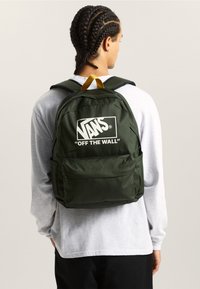 Groene stoffen rugzak met wit Vans-logo, voorzien van verstelbare riemen, een bovenhandvat en een voorvak met rits. Soepele textuur, rechthoekige vorm.