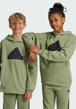 Felpe con cappuccio verdi con il logo Adidas testurizzato in nero. Il tessuto sembra morbido e entrambe le persone indossano abiti coordinati, compresi i pantaloni.