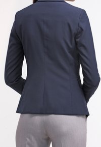 Granatowa marynarka o dopasowanym kroju, z klapami z wycięciem typu notch i gładką fakturą, wyposażona w pojedynczy tylny rozcięcie i dwie boczne kieszenie.