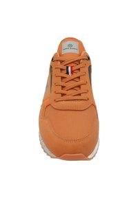 Orange sneaker i mesh och mocka, rundad tå, snörning framtill, logotyp på tungan och kontrasterande röd och blå randig detalj.